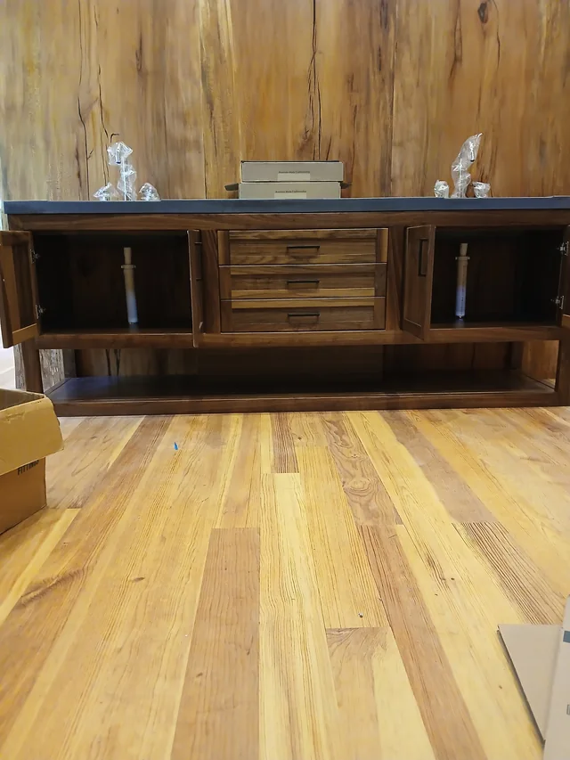 Dark wood double vanity against a natural timber wall with wood flooring